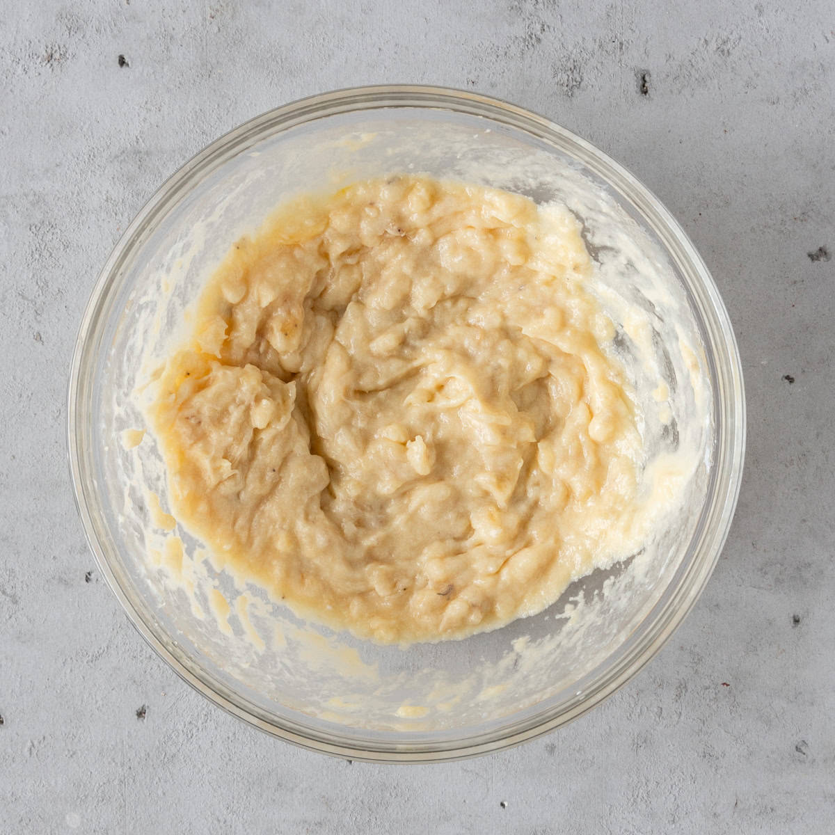 the wet ingredients combined in a glass bowl on a grey background.