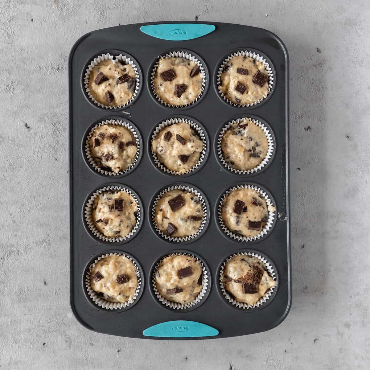 the banana chocolate chunk muffins in a muffin tin before being baked.