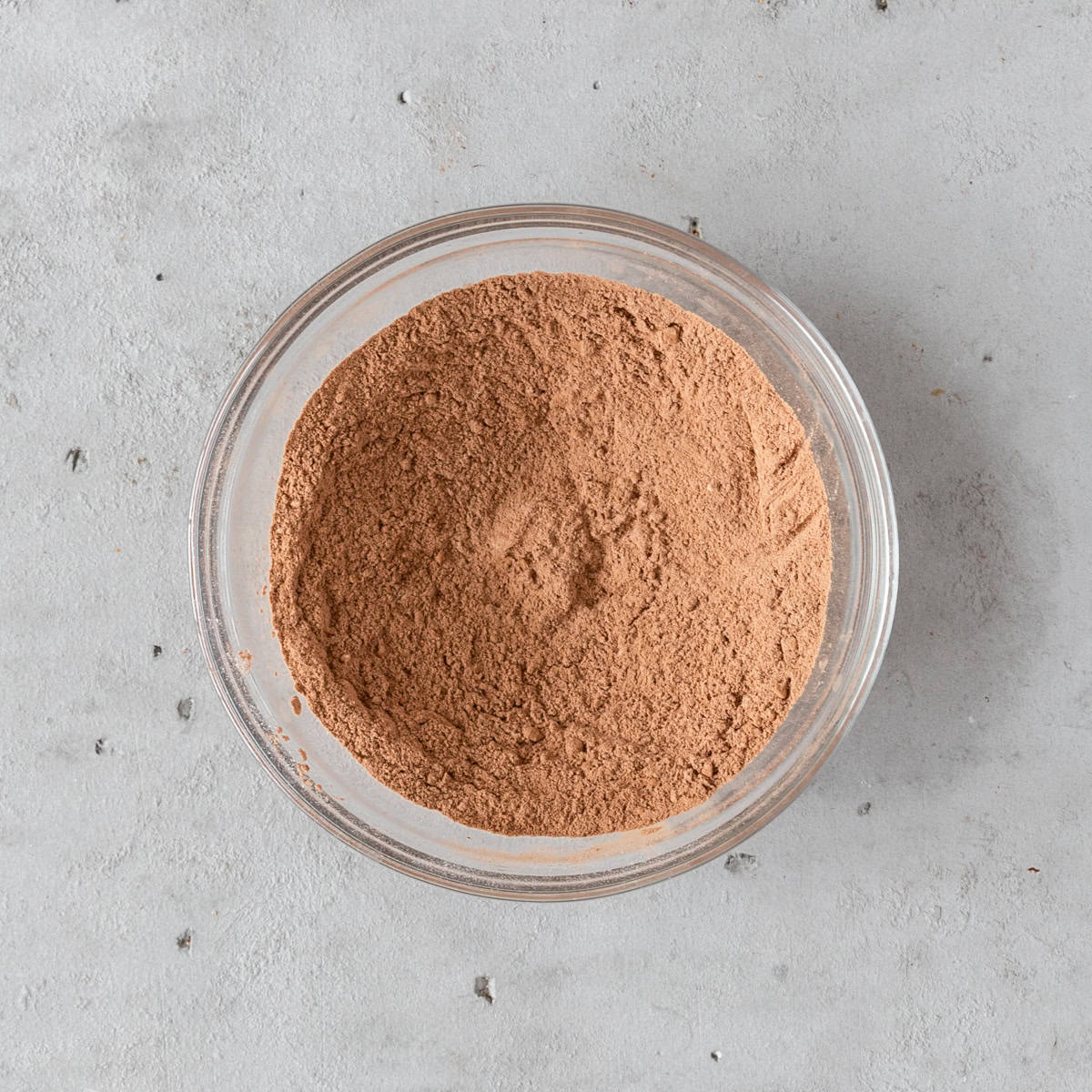 the dry ingredients combined in a glass bowl on a grey background.