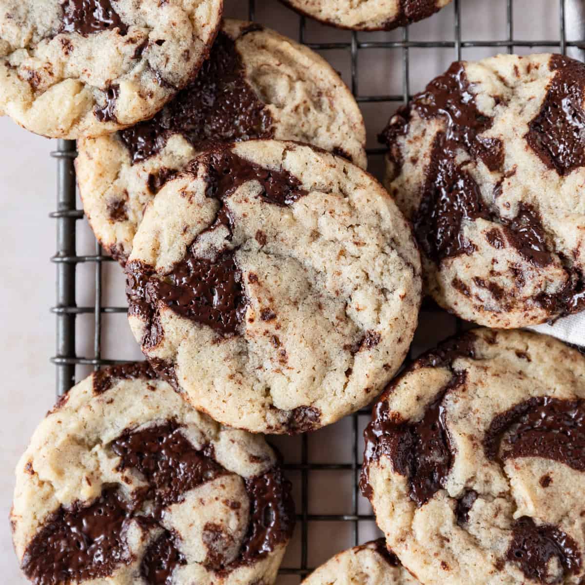 several sourdough chocolate chip cookies on a metal cooling rack.