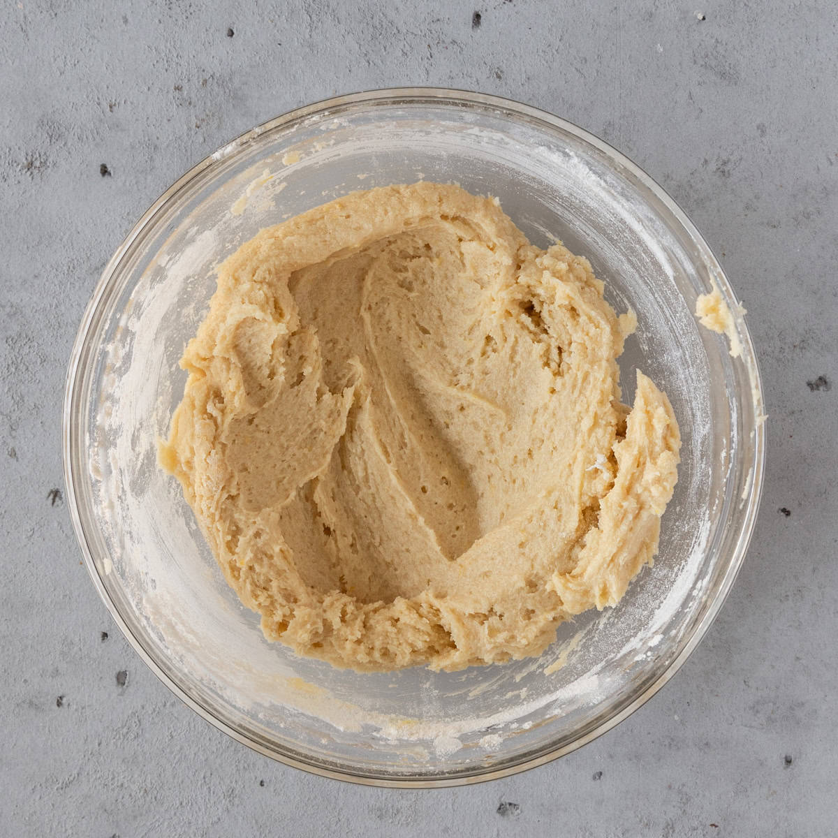 the completed batter in a glass bowl on a grey background.