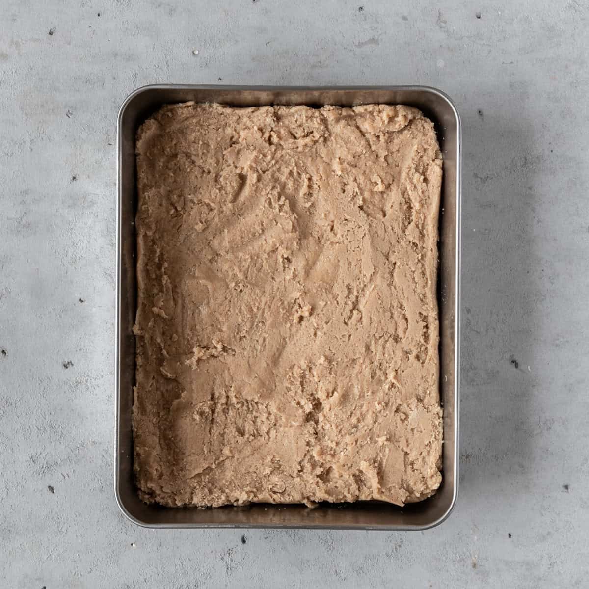 the cookie dough in a baking dish on a grey background.