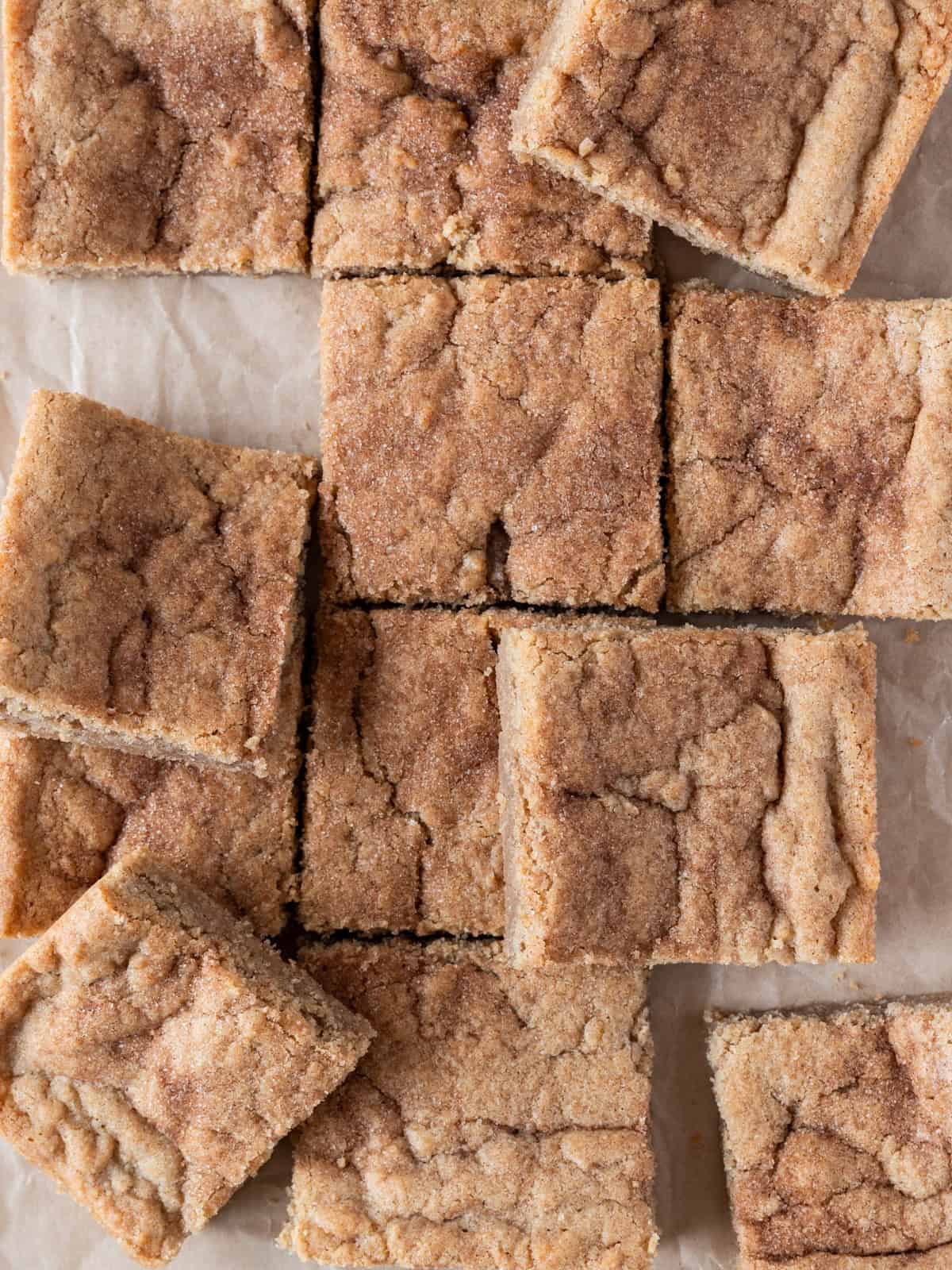 several snickerdoodle cookie bars laid out on a piece of parchment paper.
