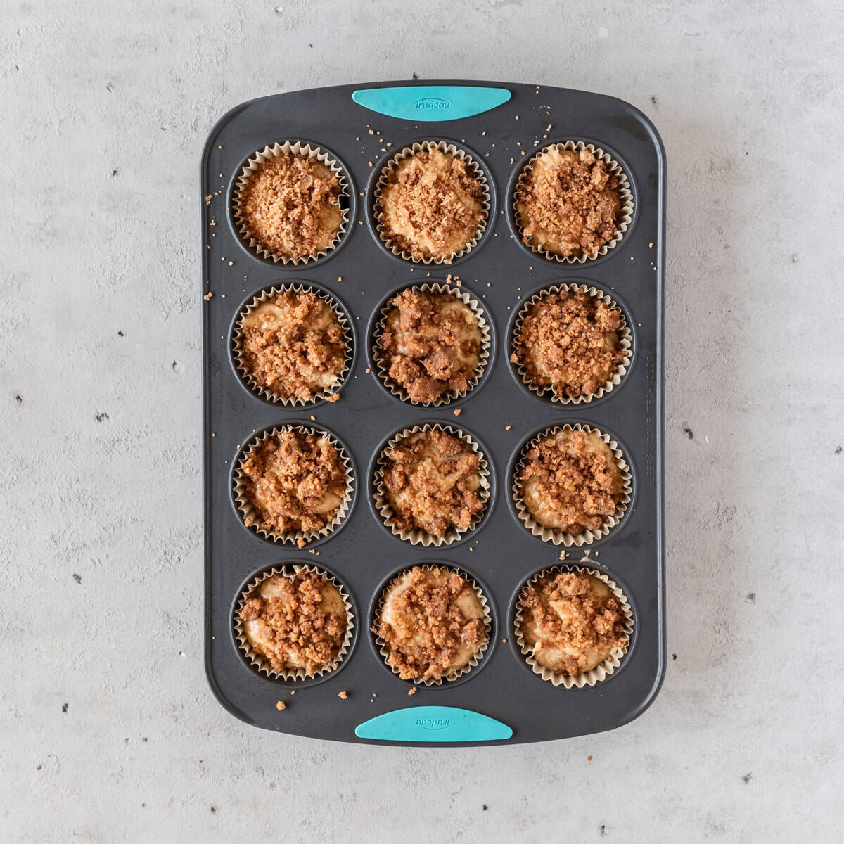 the muffin batter topped with the cinnamon crumble before being baked.
