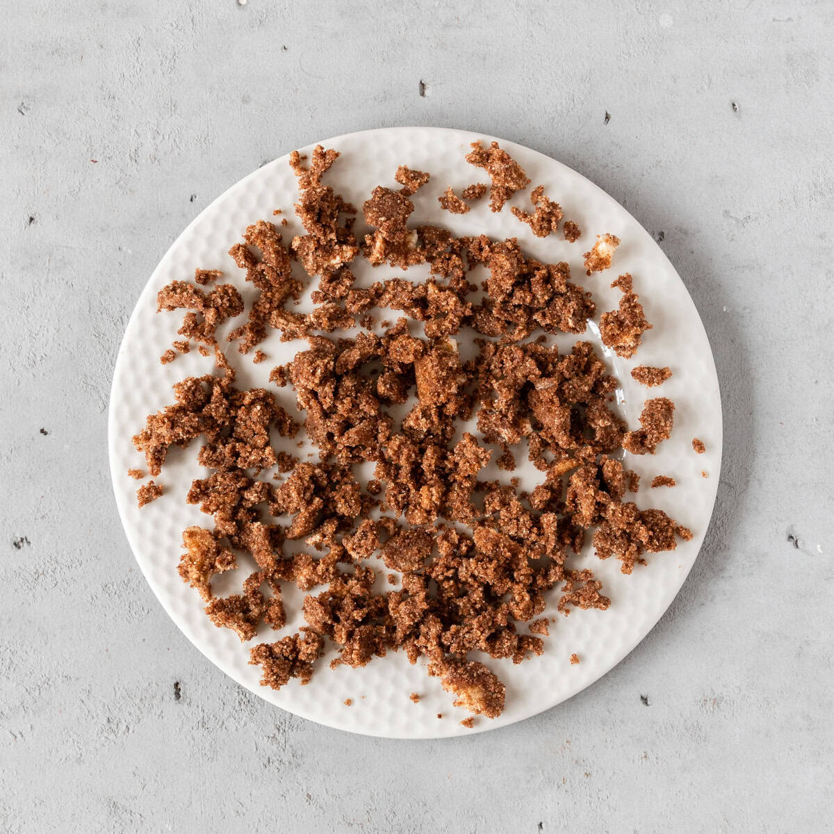 the cinnamon roll filling laid out on a plate on a grey background.