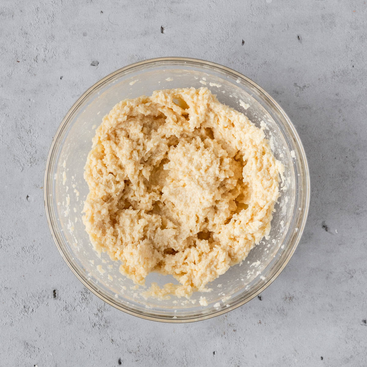 the wet ingredients combined in a glass bowl on a grey background.