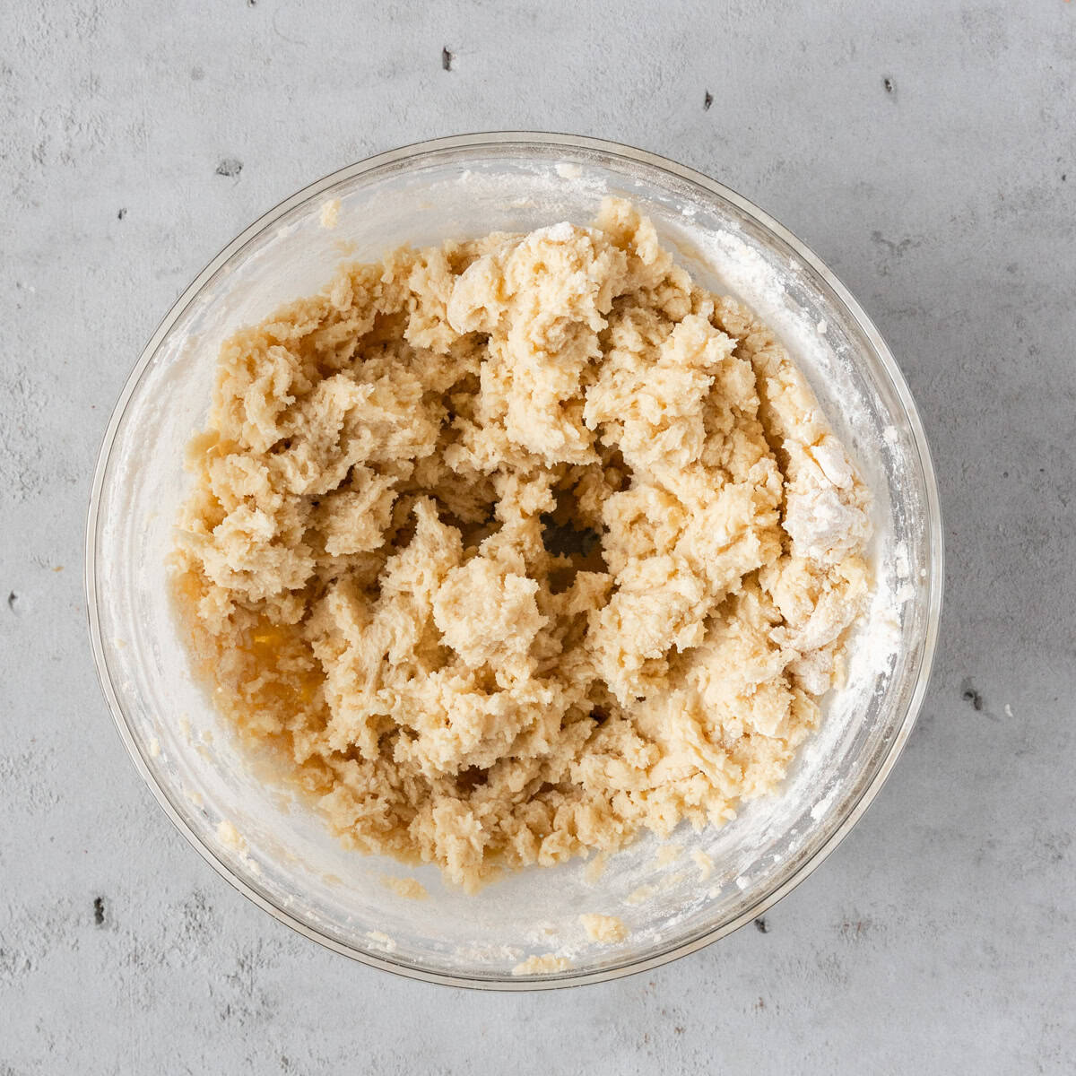 the wet and dry ingredients combined in a glass bowl on a grey background.