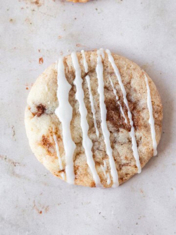 a cinnamon roll cookie on a tan background.