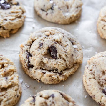 several homemade soft and chewy chocolate chip cookies on a piece of parchment paper.