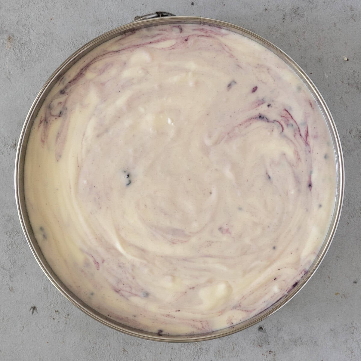 the cheesecake batter poured over the graham cracker crust in a springform pan before being baked.