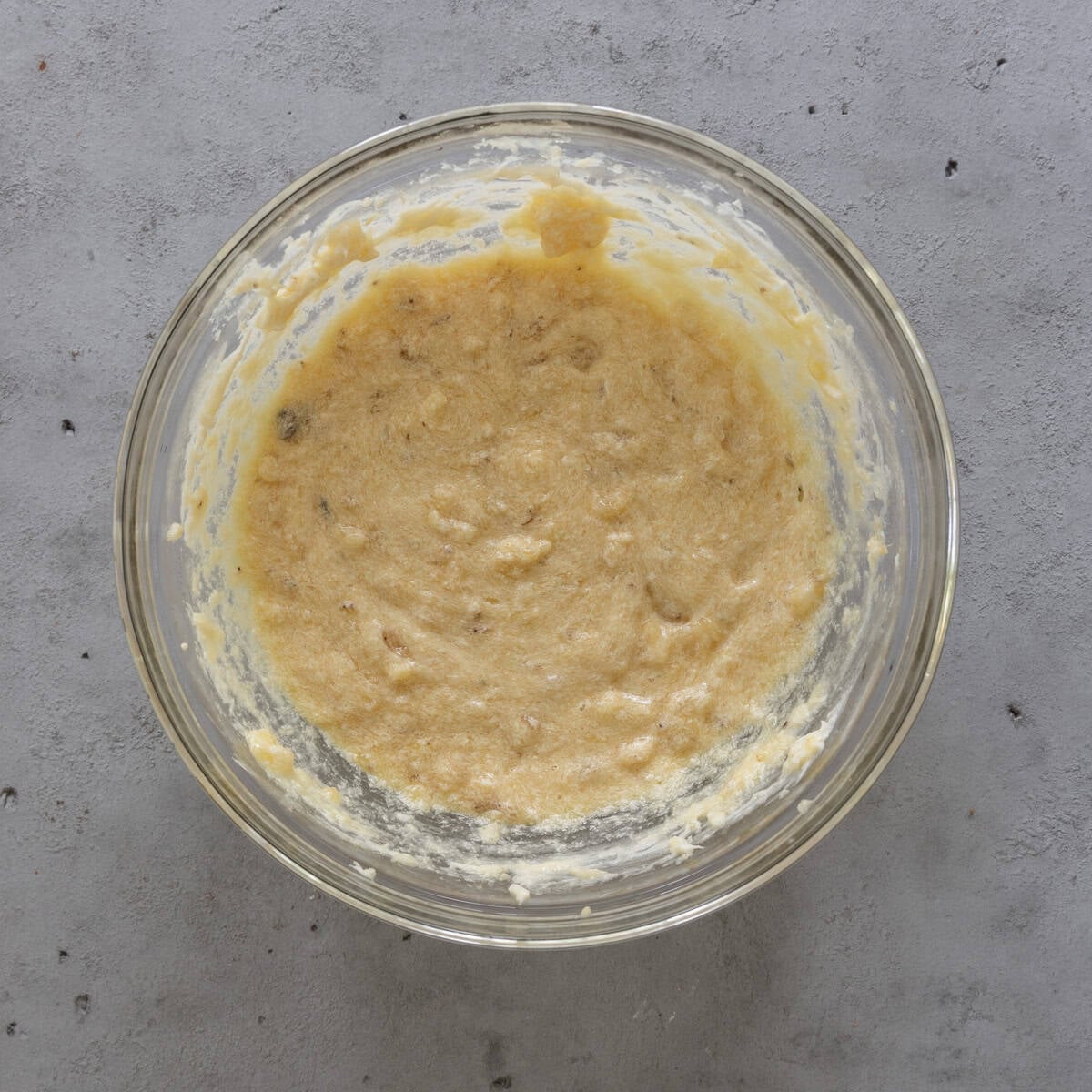 the wet ingredients combined in a glass bowl on a grey background.