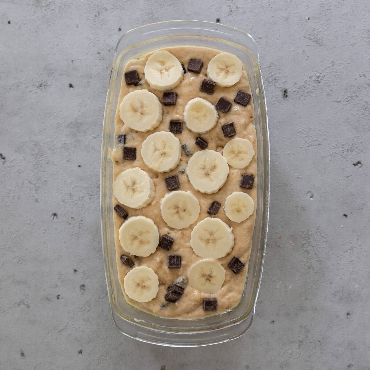 the chocolate chunk banana bread before being baked on a grey background.