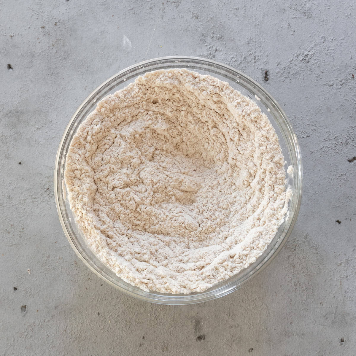 the dry ingredients combined in a glass bowl on a grey background.
