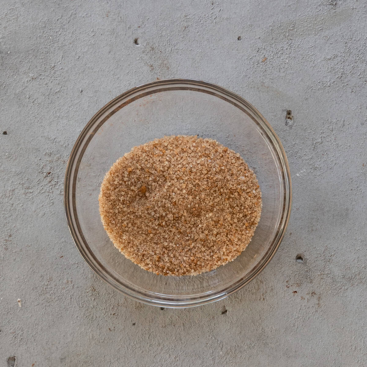 the sugar and pumpkin spice for the blondie topping combined in a glass bowl on a grey background.