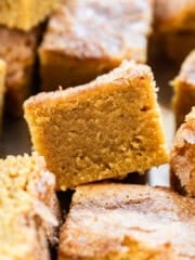several pumpkin blondies stacked on a metal tray.