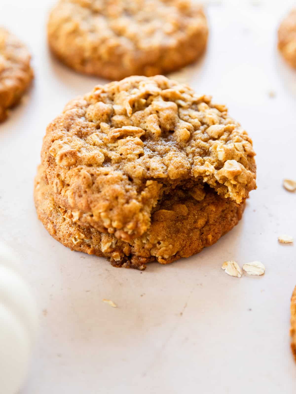 two pumpkin oatmeal cookies stacked on top of each other and one has a bite out of it.