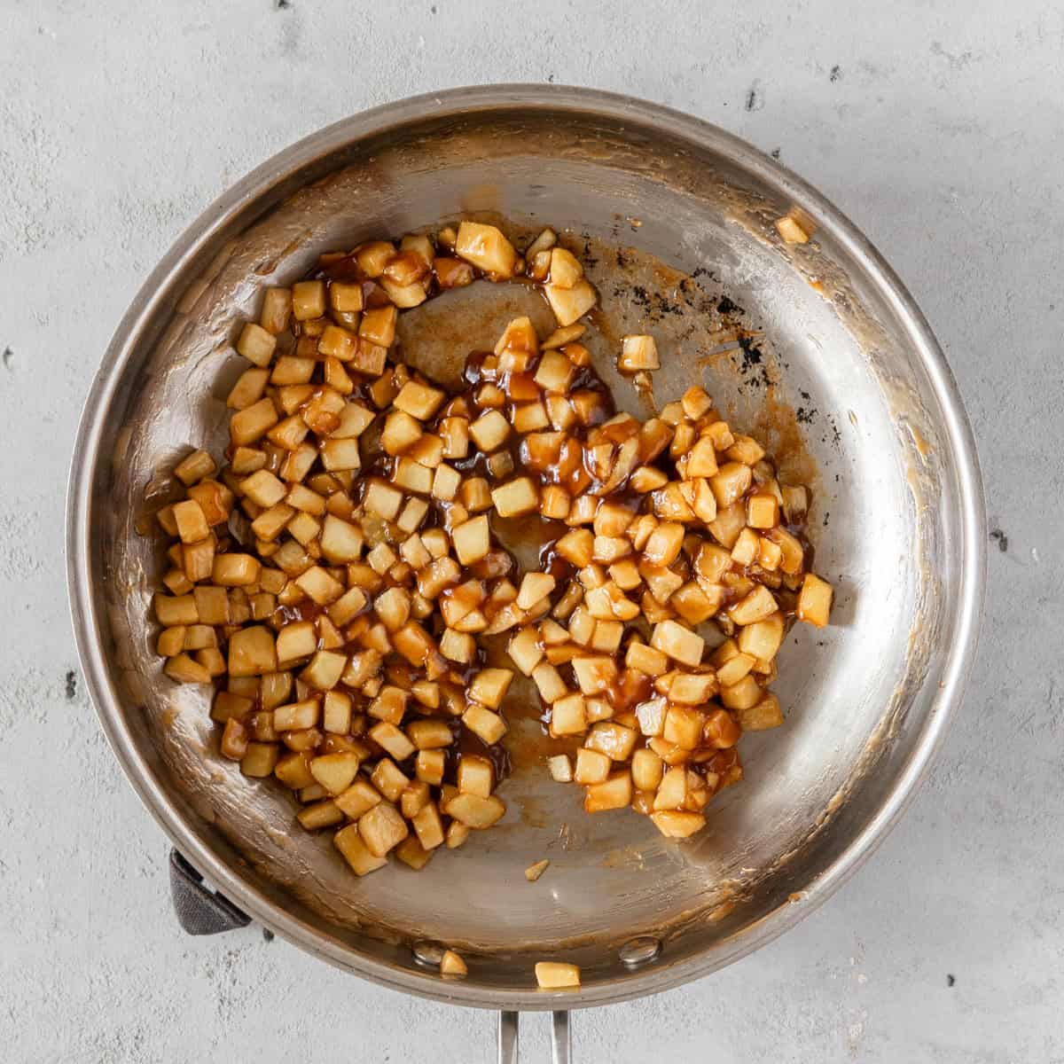 the apple pie filling after being cooked in a stainless steel pan.