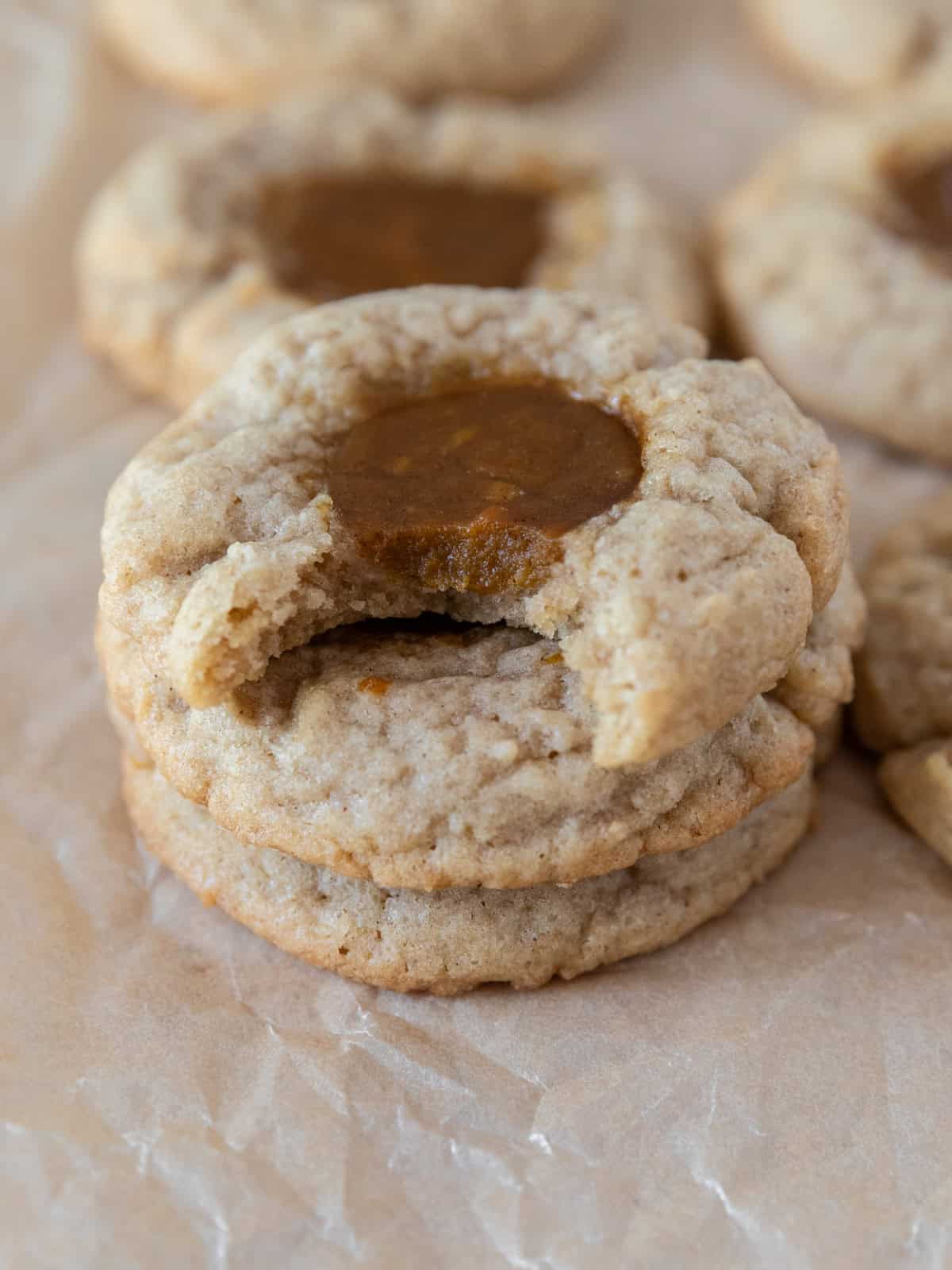 three pumpkin pie cookies stacked on top of each other. The top one has a bite out of it.