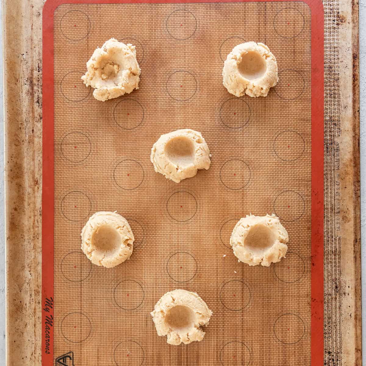 the pumpkin pie spice sugar cookie base with the wells pressed in before being baked.