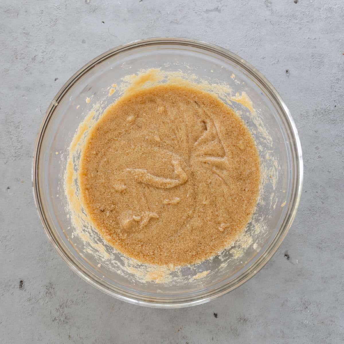 the wet ingredients combined in a glass bowl on a grey background.