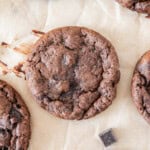 several banana cocoa cookies on a piece of parchment paper.