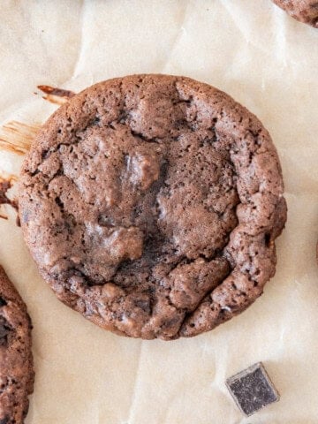 several banana cocoa cookies on a piece of parchment paper.